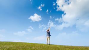 イメージ：青空の下に立つ人